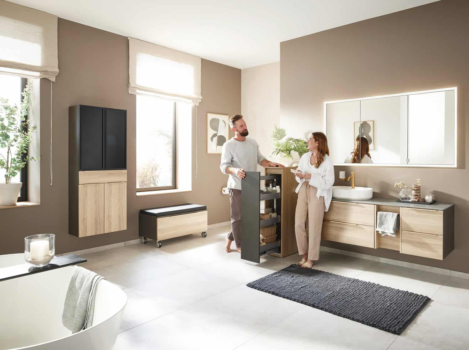 Pärchen freut sich über das neue Badezimmer von Tenne Bad & Fliesen und probiert das Badmöbel aus.